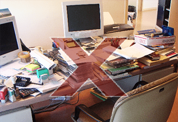Exemple d'un espace de travail encombré : un bureau mal rangé et complètement envahis de piles de documents partout en désordre, des post-it, des corbeilles...